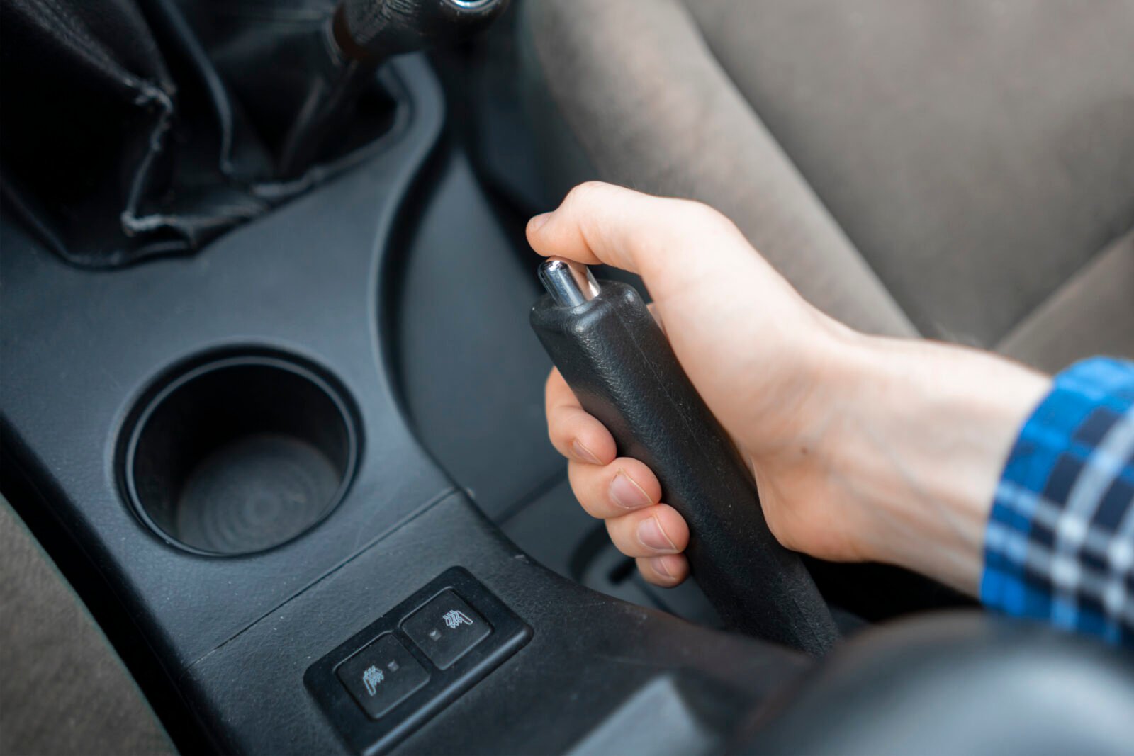 Main de conducteur actionnant le frein à main au volant d'un véhicule Main de conducteur actionnant le frein à main au volant d'un véhicule