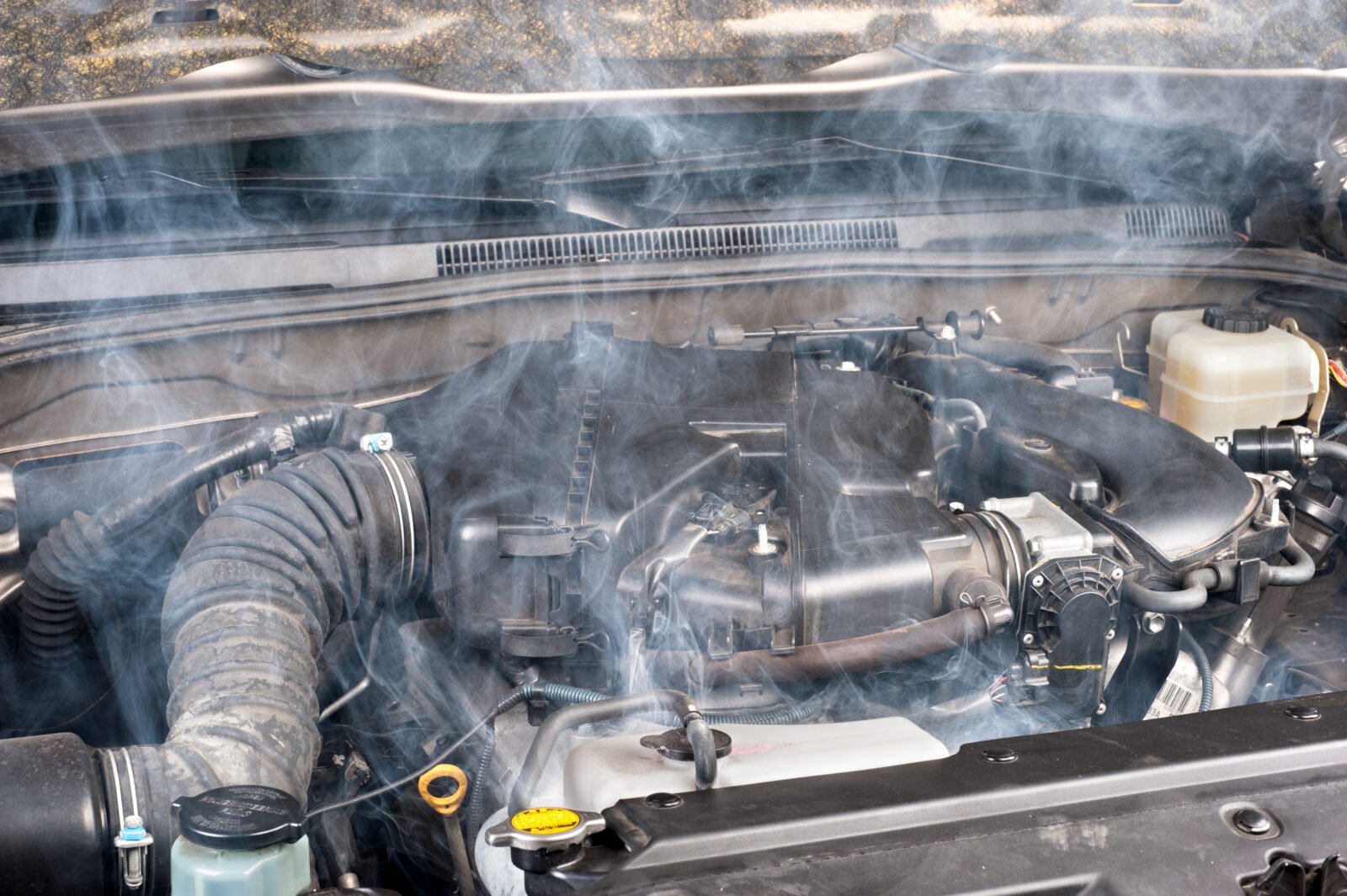 Moteur automobile en surchauffe dégageant de la fumée en plein jour