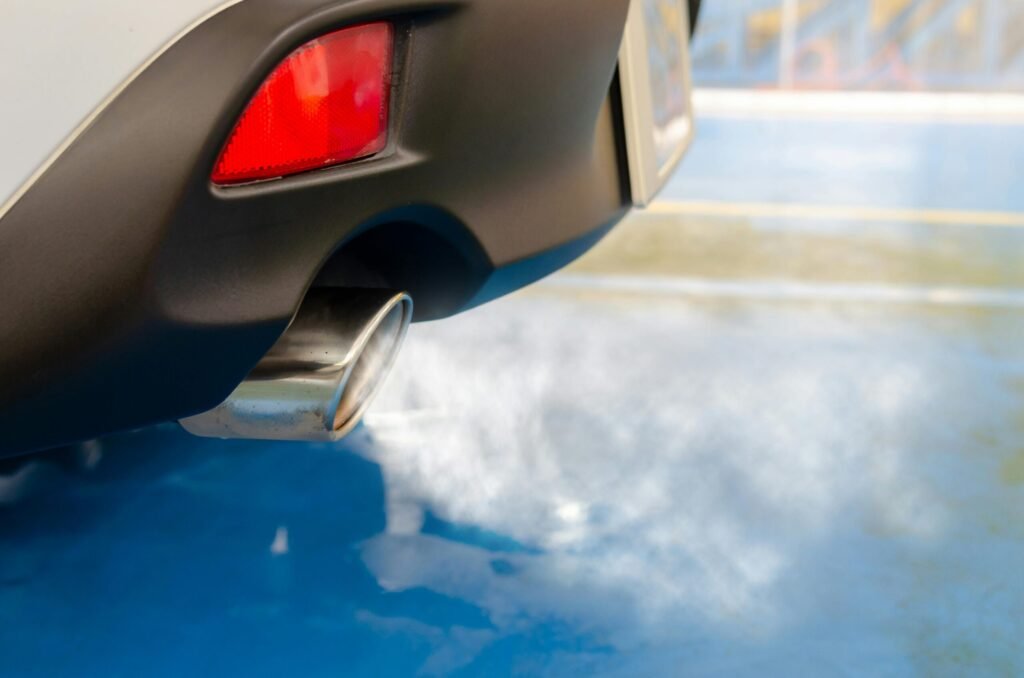 Voiture qui fume de la fumée blanche du pot d'échappement Voiture qui fume de la fumée blanche du pot d'échappement