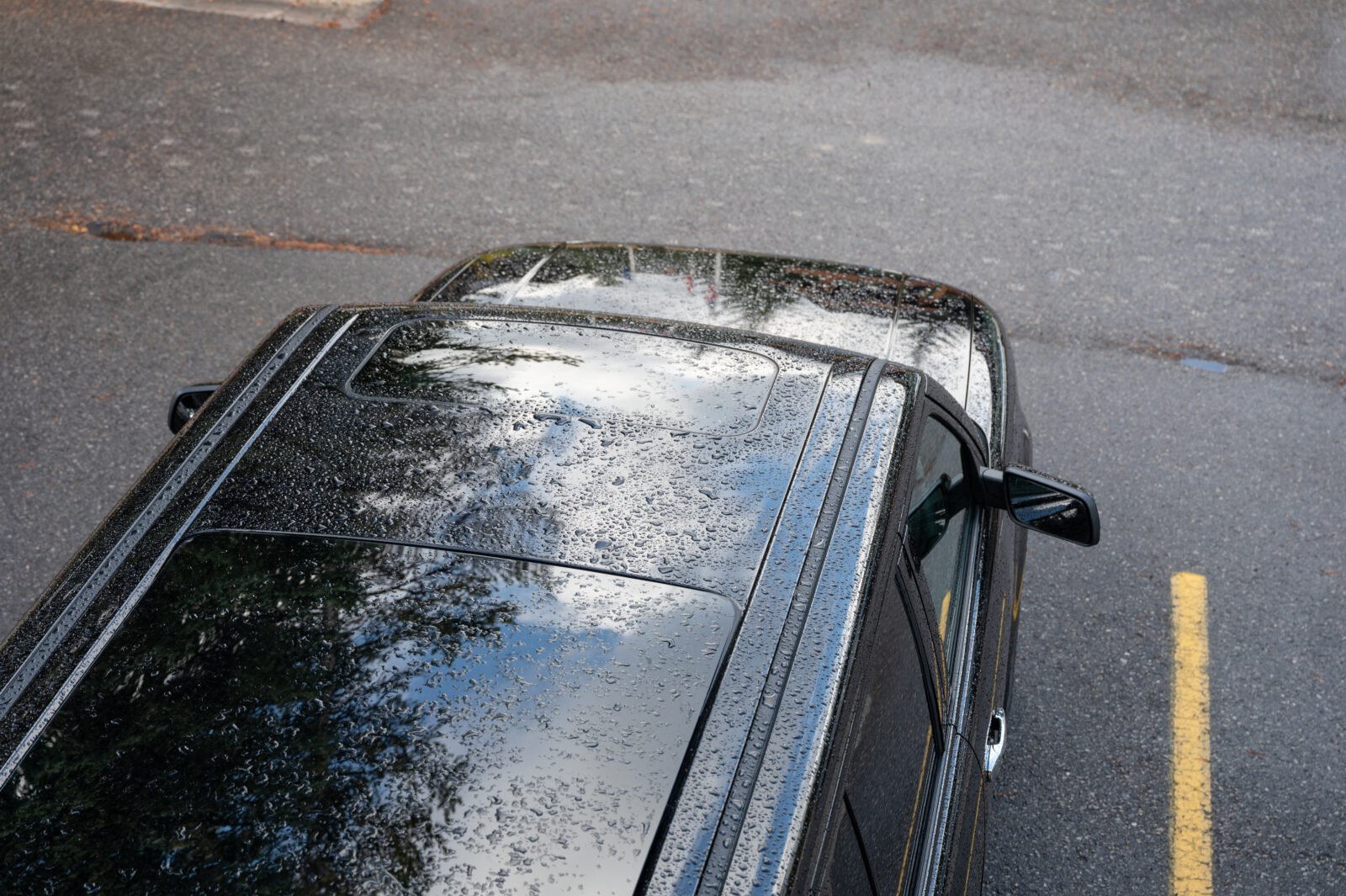 Gouttes de pluie sur le toit foncé d'une voiture stationnée