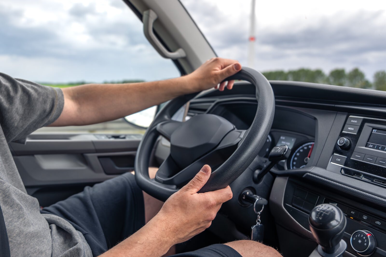 Mains posées sur le volant d'une voiture pendant la conduite